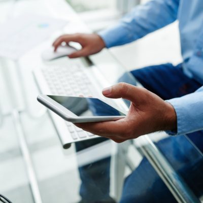 Hands of businessman using app on his phone